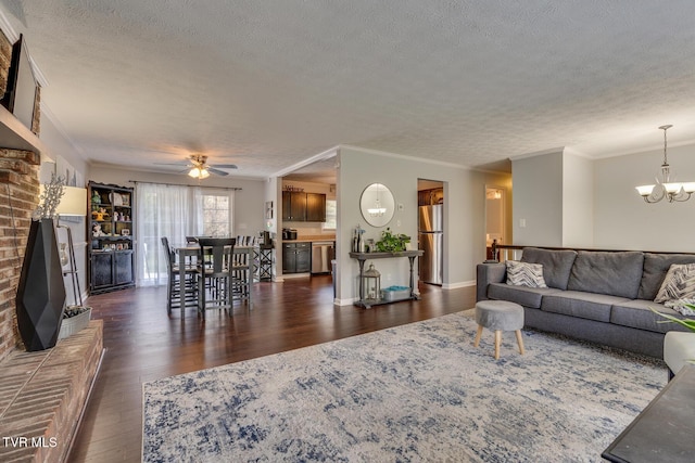 living area with crown molding, ceiling fan with notable chandelier, dark wood-style flooring, and a textured ceiling