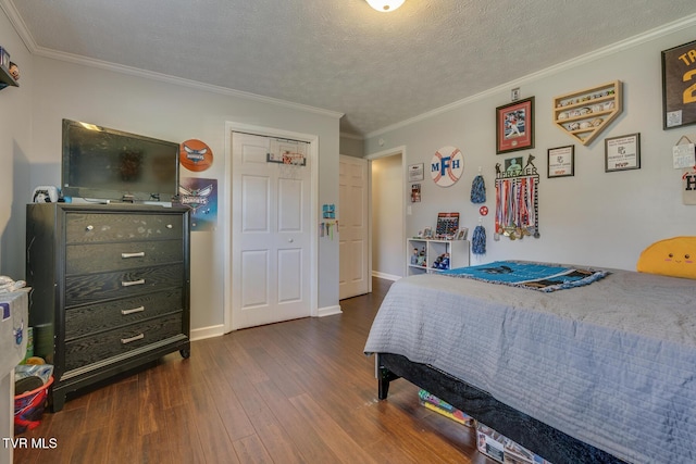 bedroom featuring baseboards, a textured ceiling, dark wood-style flooring, and crown molding