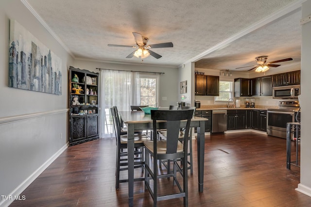 dining area with dark wood finished floors, plenty of natural light, crown molding, and a ceiling fan