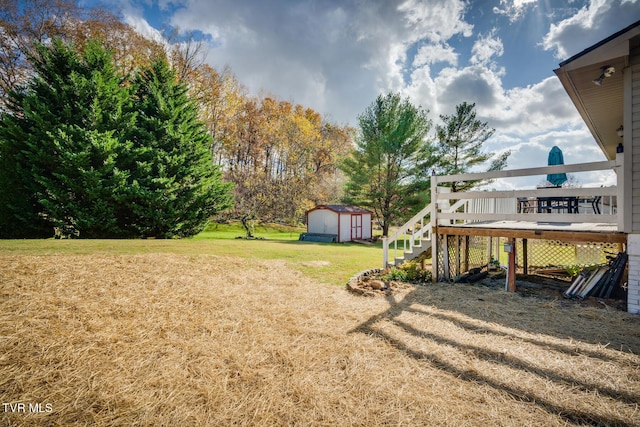 view of yard with a storage unit, a wooden deck, and an outdoor structure