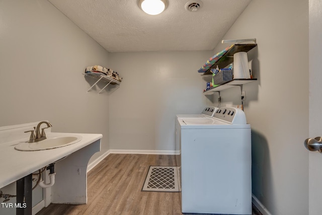 laundry area with visible vents, washing machine and dryer, laundry area, and light wood-style flooring