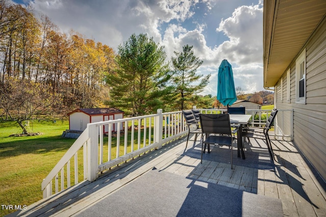 view of patio / terrace with outdoor dining area, a storage shed, an outdoor structure, and a deck