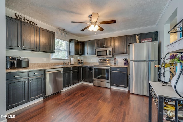 kitchen with crown molding, dark wood-style floors, light countertops, and stainless steel appliances