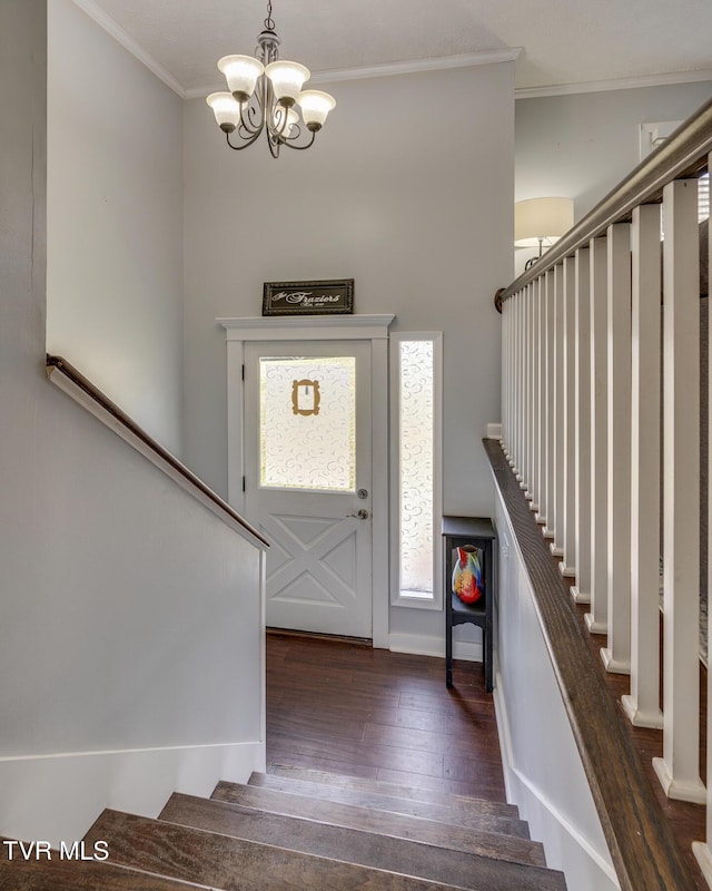 foyer with stairway, wood-type flooring, an inviting chandelier, and ornamental molding