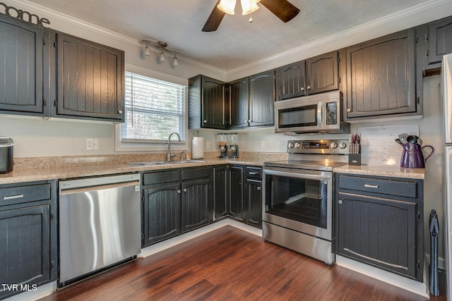 kitchen with a sink, stainless steel appliances, crown molding, light countertops, and dark wood-style flooring