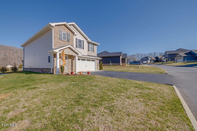 traditional-style home featuring aphalt driveway, brick siding, a garage, and a front yard