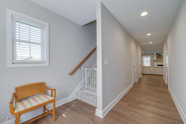 hall with recessed lighting, stairway, baseboards, and wood finished floors