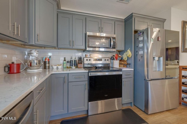 kitchen with appliances with stainless steel finishes and gray cabinetry