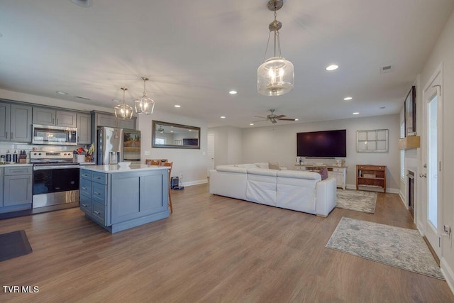 living room with visible vents, recessed lighting, wood finished floors, and baseboards