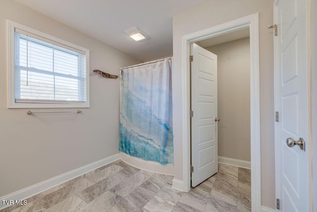 bathroom with curtained shower and baseboards