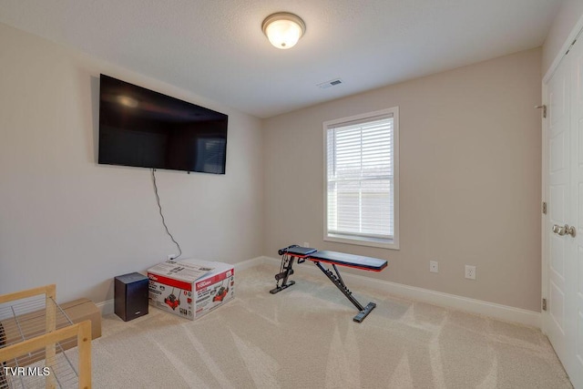 exercise area featuring visible vents, baseboards, and carpet