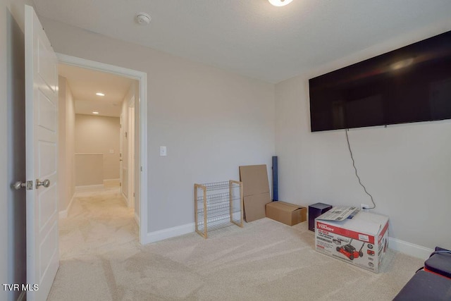 interior space with baseboards and light carpet