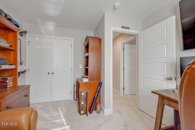 interior space featuring a closet, light carpet, and baseboards