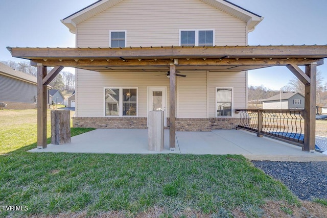 rear view of house featuring a yard, a ceiling fan, a patio, and brick siding