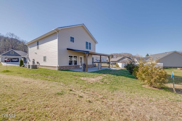 rear view of property with central AC unit, a patio area, and a lawn