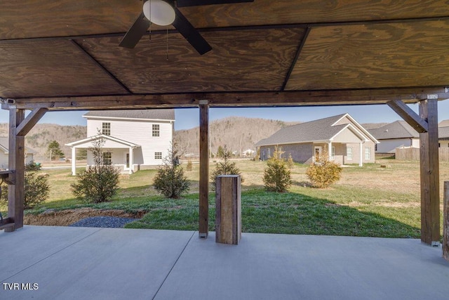 view of patio with a mountain view, an outdoor structure, and a ceiling fan