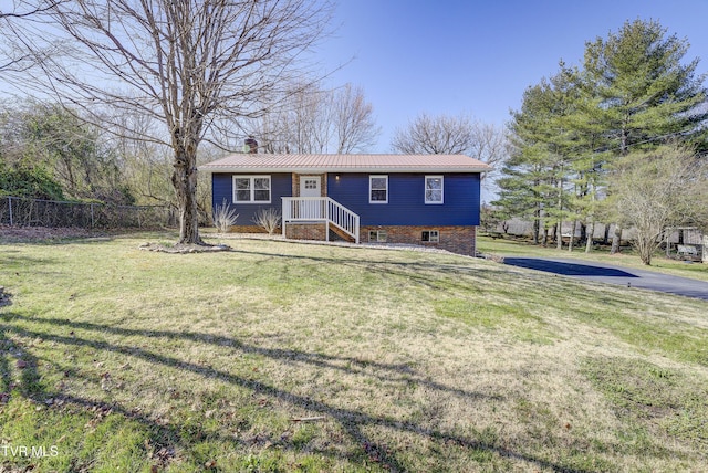 single story home with a front yard, fence, a chimney, and metal roof