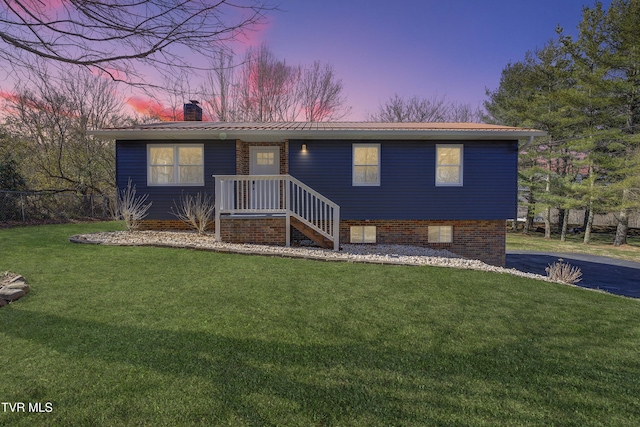 view of front of home featuring metal roof, a lawn, and a chimney