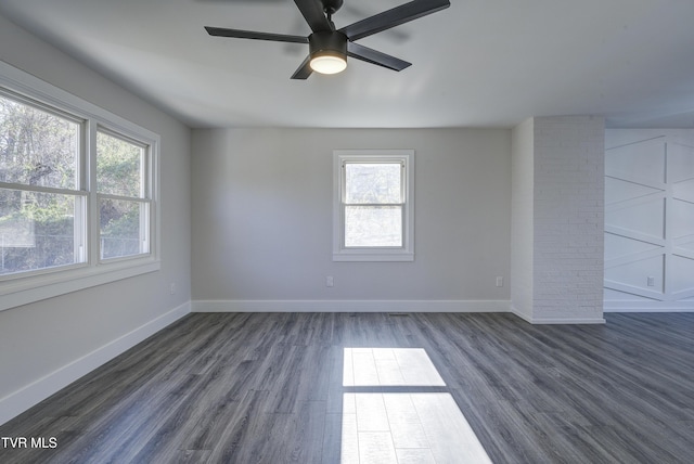 spare room with dark wood-style floors, ceiling fan, and baseboards