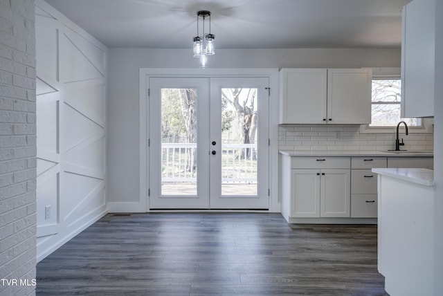 kitchen featuring dark wood finished floors, white cabinets, french doors, and a sink