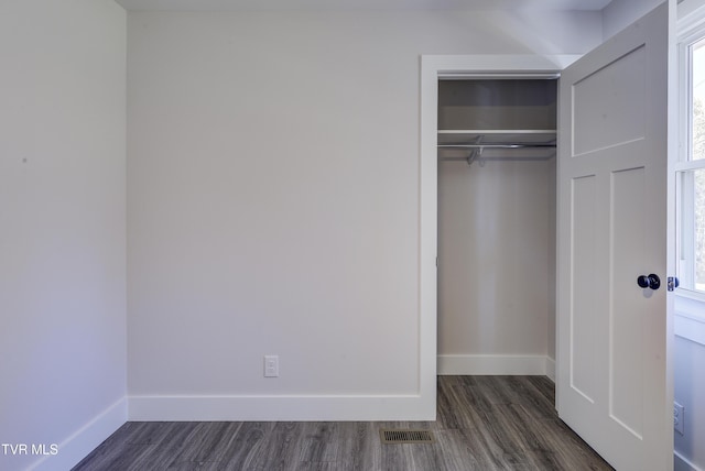 interior space with visible vents, dark wood-style floors, a closet, and baseboards