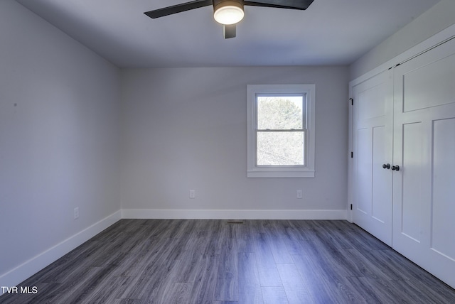 unfurnished bedroom featuring baseboards and dark wood-style flooring