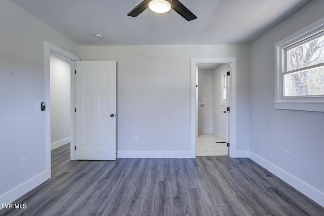 unfurnished bedroom featuring wood finished floors, baseboards, and ceiling fan