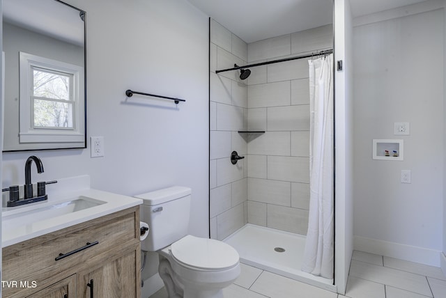 bathroom featuring tile patterned floors, tiled shower, toilet, and vanity