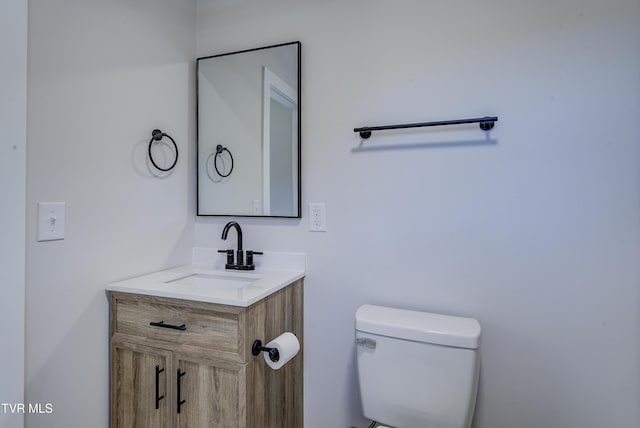 half bath featuring toilet and vanity