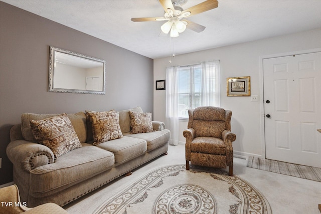 carpeted living area with baseboards and a ceiling fan