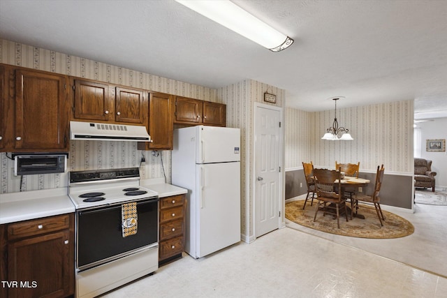 kitchen featuring range hood, wallpapered walls, freestanding refrigerator, light countertops, and electric stove