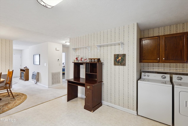 washroom featuring visible vents, baseboards, wallpapered walls, cabinet space, and independent washer and dryer