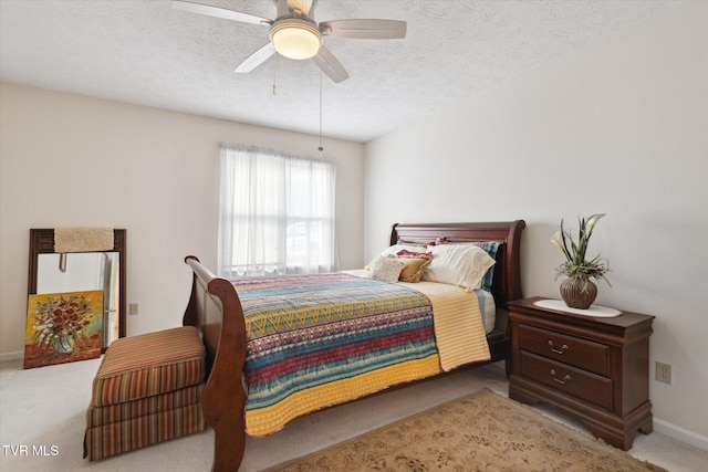 carpeted bedroom featuring a ceiling fan and a textured ceiling