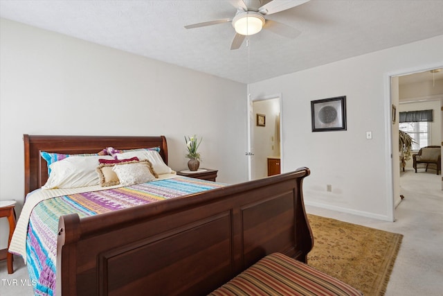 bedroom featuring baseboards, light colored carpet, and a ceiling fan