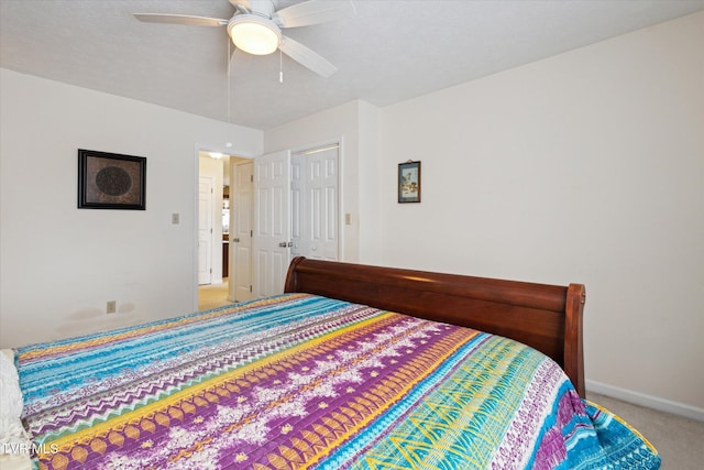 bedroom with a ceiling fan, light colored carpet, baseboards, and a closet