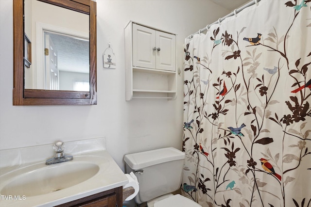 bathroom with curtained shower, toilet, vanity, and a textured ceiling