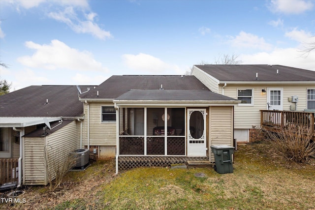 back of house with a yard, central AC unit, a sunroom, and a shingled roof