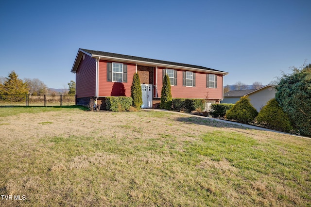 bi-level home with a front lawn and fence