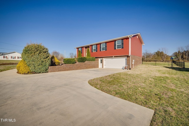 bi-level home featuring brick siding, a front lawn, fence, concrete driveway, and an attached garage