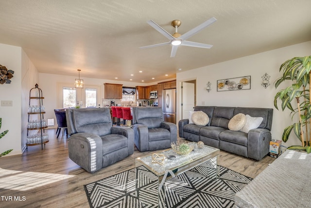 living room with recessed lighting, light wood-type flooring, and a ceiling fan