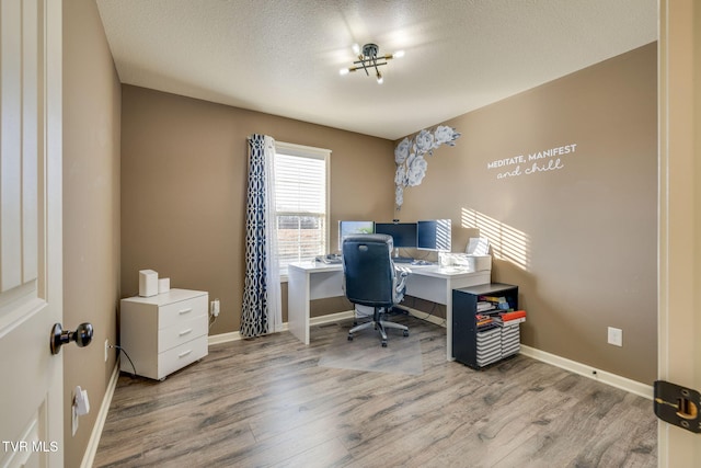 office area featuring baseboards, a textured ceiling, and wood finished floors