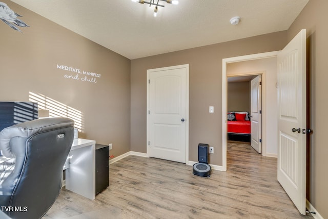 office space with baseboards and light wood-style floors