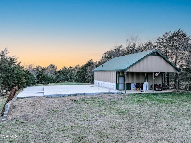 exterior space with an outbuilding, metal roof, and a front lawn