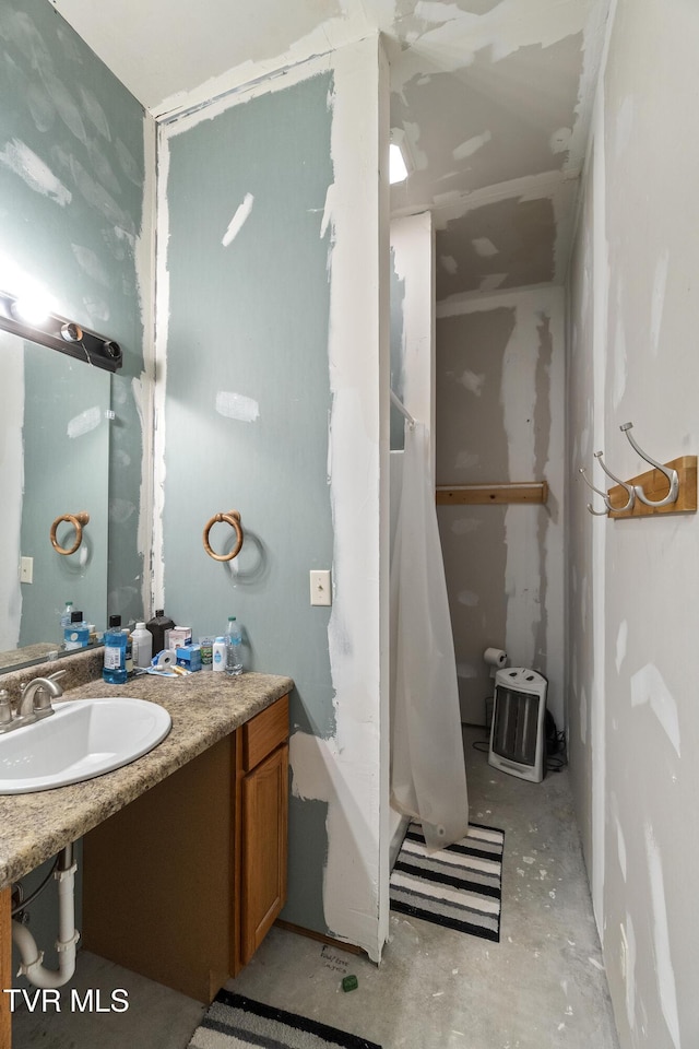 full bathroom featuring a sink, curtained shower, and concrete flooring