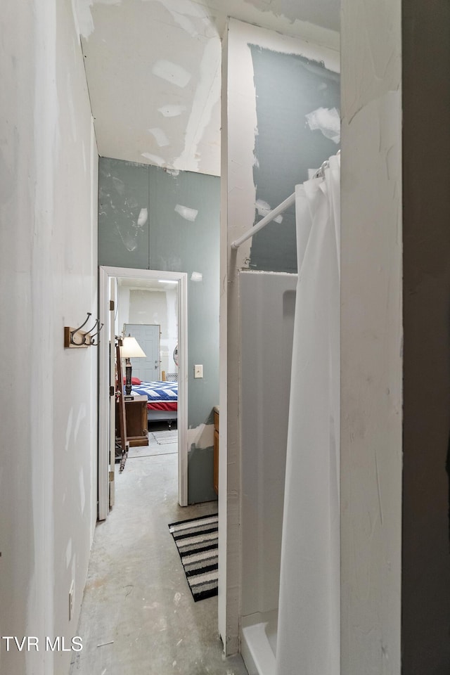 full bath with unfinished concrete flooring and a shower with curtain