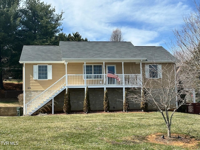 rear view of house featuring stairway, a yard, and covered porch