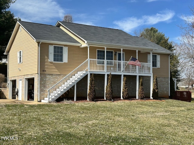 rear view of house with brick siding, a garage, stairs, and a yard