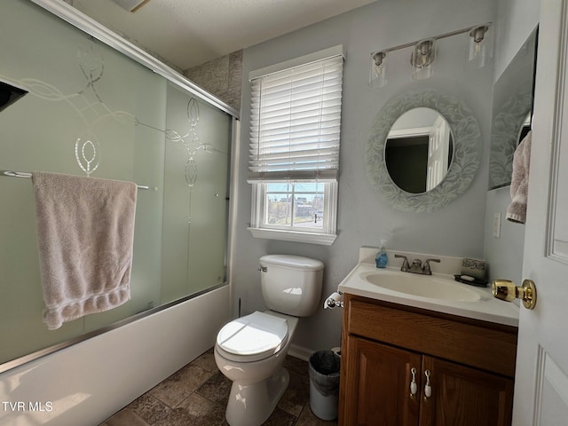 bathroom with stone finish floor, toilet, vanity, and shower / bath combination with glass door