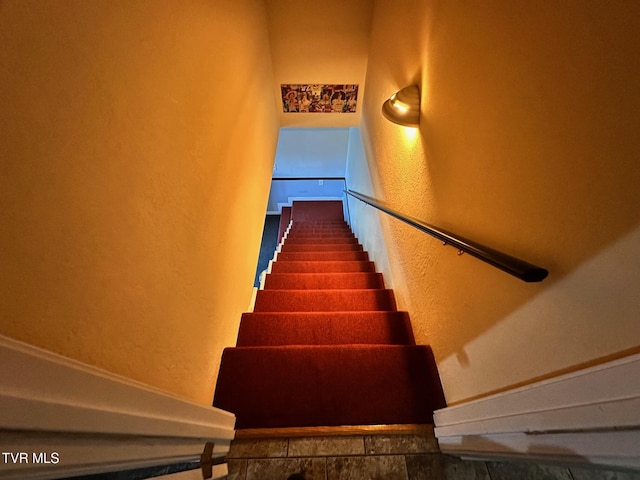 stairway featuring a textured wall