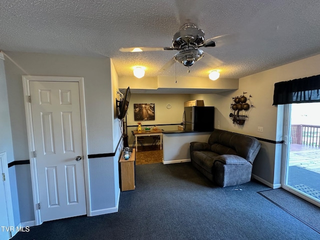 living area featuring baseboards, a textured ceiling, ceiling fan, and dark colored carpet